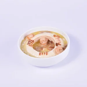 Top-down view of a traditional Middle Eastern meat broth bowl featuring grilled kofta meatballs and chickpeas in a white ceramic bowl on a clean white background.