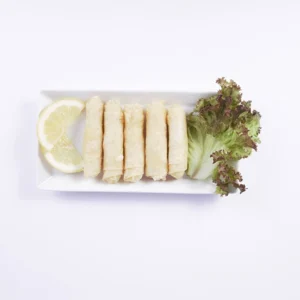 Overhead flat-lay view of a rectangular white plate with four golden crispy stuffed rolls, garnished with fresh lemon slices and red lettuce on a white background.