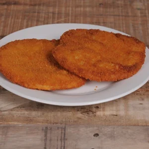 Overhead flat-lay view of crispy golden fried shrimp arranged on a white round plate, with the tails pointing outward, set against a rustic wooden background.