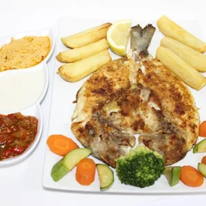 A white platter featuring a whole grilled fish, golden fries, steamed veggies, and a side dish with three separate dipping sauces.
