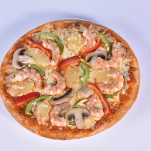 A whole seafood pizza topped with shrimp, mushrooms, green and red bell peppers, and pineapple chunks on a white background.