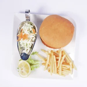 A golden crispy chicken sandwich in a soft bun served with creamy coleslaw, golden fries, and a lemon wedge on a white plate.