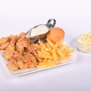 A white rectangular plate with crispy golden fried shrimp, french fries, a soft bun, a metal gravy boat with creamy dip, and a glass bowl of coleslaw.
