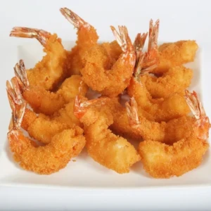 A close-up of a white square plate filled with golden-brown panko breaded fried shrimp, with their red tails pointing upward, set against a clean white background.