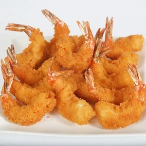 A close-up of a white plate filled with golden, ultra-crispy Panko breaded shrimp with their tails intact, arranged beautifully and ready to serve.