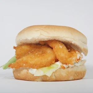 A close-up side view of a crispy fish fillet sandwich with a golden breaded fillet, fresh lettuce, and creamy sauce in a soft bun.