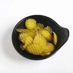A close-up of a black leaf-shaped bowl filled with golden yellow crinkle-cut pickle chips, set against a white background.
