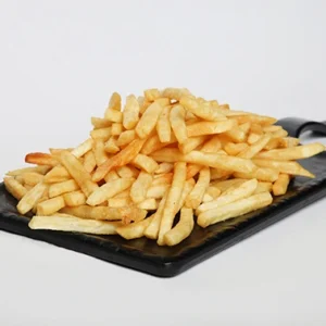 A large, overflowing mound of golden crispy French fries piled high on a rectangular black slate serving board, set against a plain white studio background.