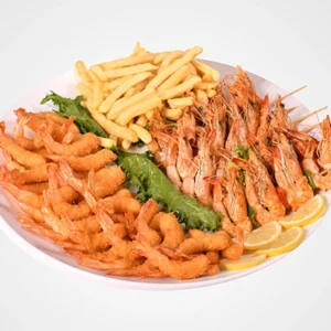 A large white platter filled with crispy fried breaded prawns on the left, grilled whole shrimp on the right, golden french fries at the top, fresh lettuce in the center, and lemon slices at the bottom.